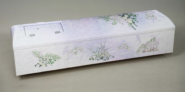 葛飾区メモリーホーム新小岩の棺の写真。白地に淡い紫のグラデーション。繊細な花柄が描かれたエレガントな棺。