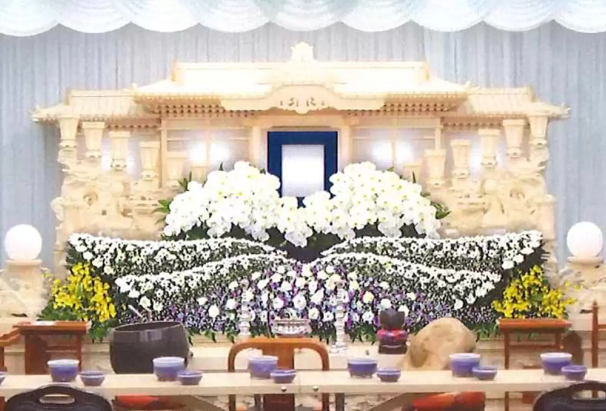 葛飾区メモリーホーム新小岩の祭壇の写真。白を中心にした花々が美しく飾られた祭壇。