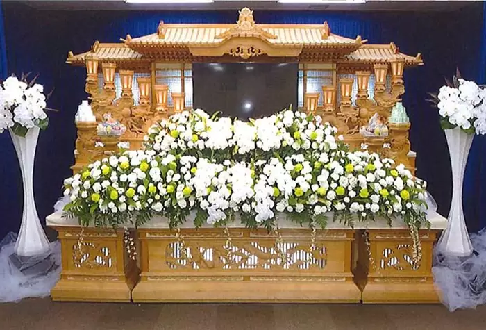 葛飾区メモリーホーム新小岩の祭壇の写真。豪華な木製装飾と白い花が目を引く伝統的な祭壇。